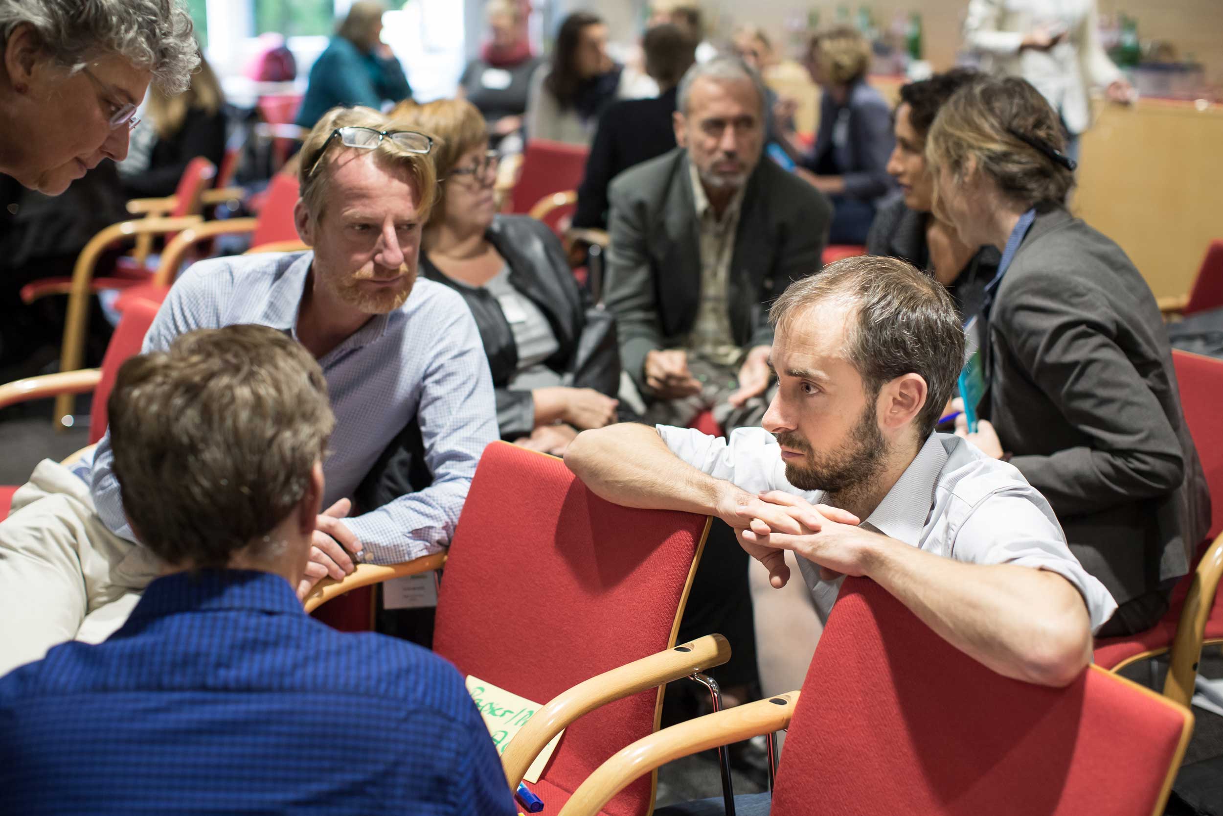 Deutsches Lehrerforum Teilnehmer sitzen nah zusammen und unterhalten sich.