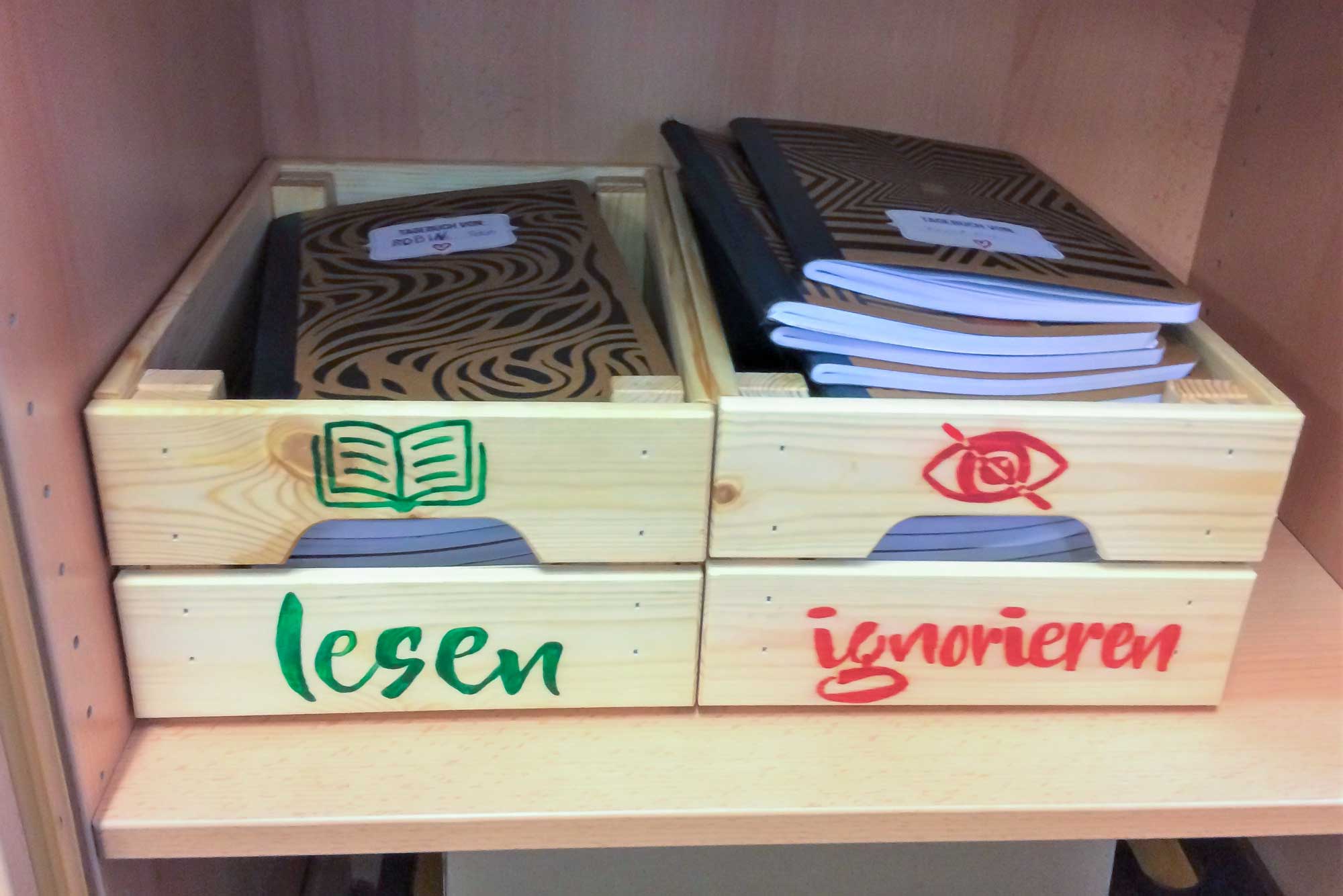 Zwei Kisten mit den Aufschriften Lesen und Ignorieren in denen die Change Writers Tagebücher der Schüler*innen liegen